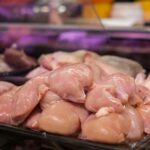 Fresh raw chicken breasts displayed in a supermarket setting, ready for purchase.